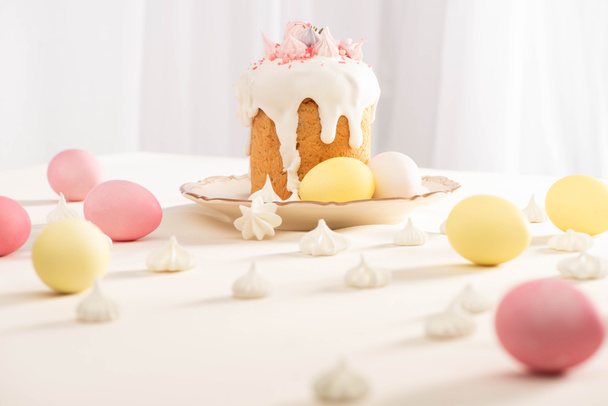 selektivní zaměření lahodného velikonočního dortu v blízkosti malovaných vajec a meringue - Fotografie, Obrázek