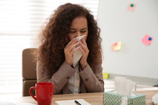 Sick African-American woman at workplace. Influenza virus - Foto, afbeelding
