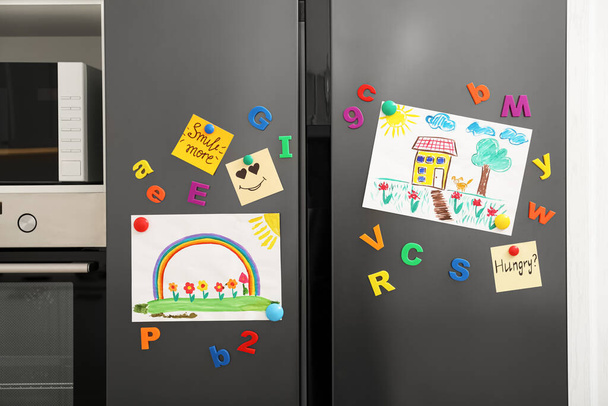 Modern refrigerator with child's drawings, notes and magnets in kitchen - Foto, Imagen