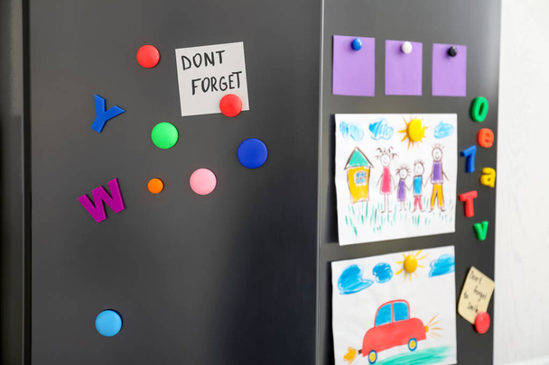 Modern refrigerator with child's drawings, notes and magnets, closeup - Фото, изображение