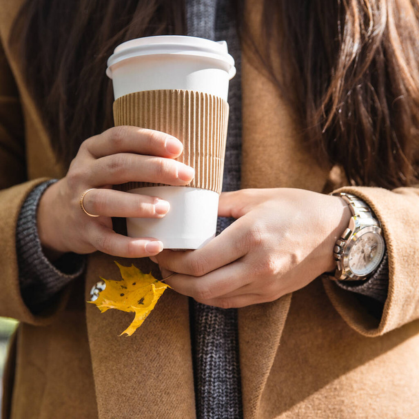 woman holding coffee cup drink to go autumn fall season yellow leaves - Photo, Image