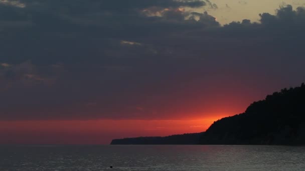 海の上に赤い夕日。太陽は地平線に触れる。赤い空、黄色の太陽と素晴らしい海。夏の夕日の海。大西洋のビーチの夕日。雲の中の太陽幻想的な自然の夕日 - 映像、動画