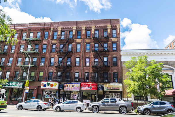 Nueva York, Estados Unidos - 4 de agosto de 2018: Calle con antiguos edificios de apartamentos típicos con su escalera de incendios y gente en el barrio de Harlem en Manhattan, Nueva York, Estados Unidos
 - Foto, imagen