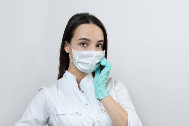 Una ragazza medico in guanti di lattice e un cappotto bianco si sta preparando per le procedure
. - Foto, immagini