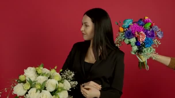 Confident brunette woman standing with crossed arms and choosing flowers with smile - Video
