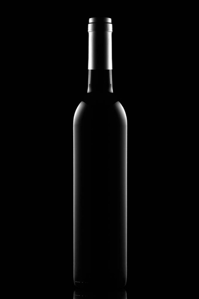 Bottle of dry red wine on a black background - Photo, image