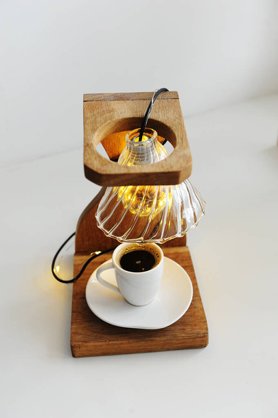 Креативний художній світильник ручної роботи з дерев'яної крапельної підставки для кави, крапельниці v60 та світла. Чашка чорної кави в нижній дошці. Концепція кави третьої хвилі
 - Фото, зображення