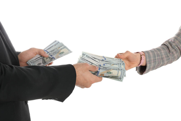 Man giving bribe money to woman on white background, closeup of hands - Valokuva, kuva