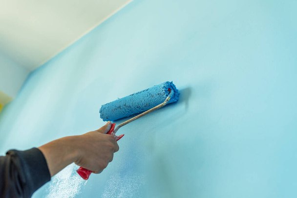 Decorator's hand painting wall with roller. - Foto, immagini