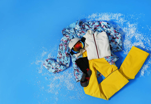 Stylish winter sport clothes on light blue background, flat lay - Фото, изображение