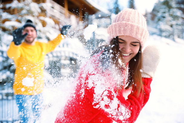 Happy couple playing snowballs outdoors. Winter vacation - Photo, Image