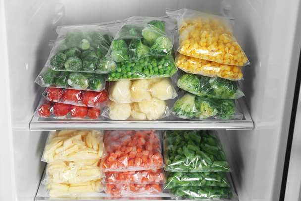Plastic bags with different frozen vegetables in refrigerator - Fotoğraf, Görsel