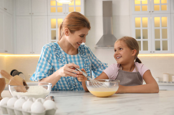 Mother and daughter making dough together in kitchen - Photo, Image