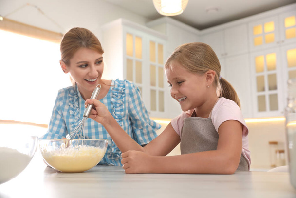 Mother and daughter making dough together in kitchen - Photo, Image