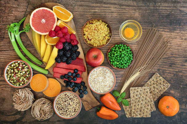 Health food for a healthy diet concept with foods high in antioxidants, anthocyanins, vitamins, minerals, protein, smart carbs, omega 3 and fiber. Flat lay on rustic wood background. - Photo, Image