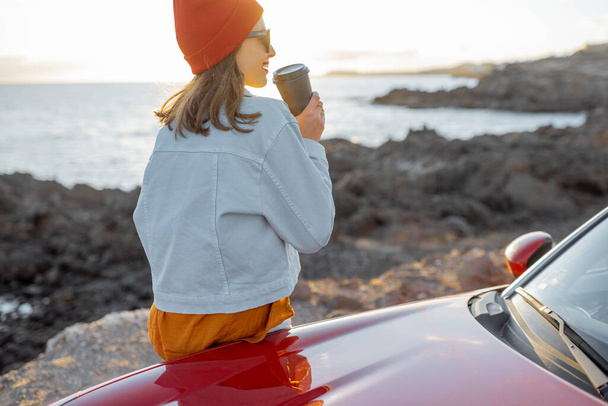 Woman traveling by car on the rocky coastline - Foto, immagini