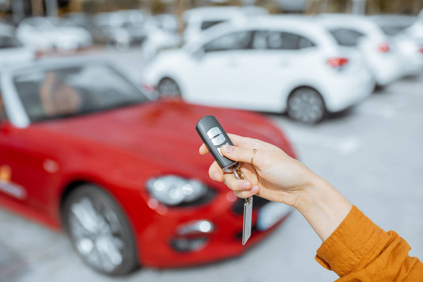 Woman holding keychain at the car parking - Zdjęcie, obraz