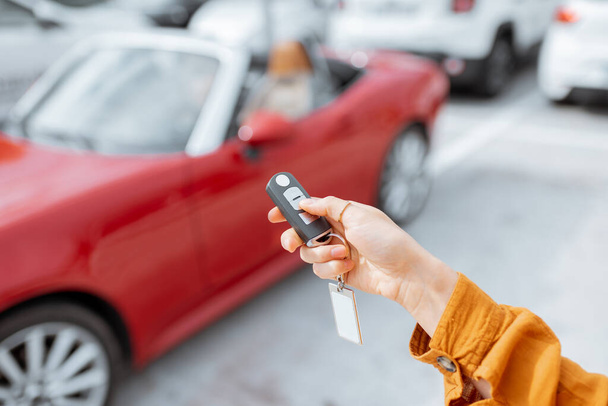 Woman holding keychain at the car parking - Photo, Image