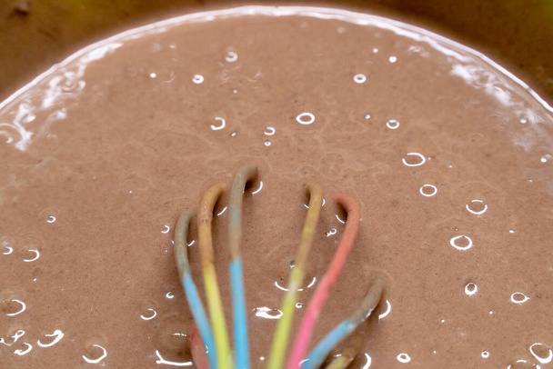 Mulheres mão chicotes creme de chocolate em uma tigela de plástico
 - Foto, Imagem