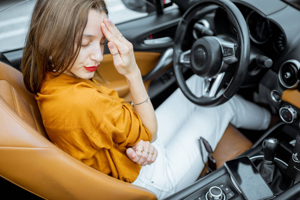 Nainen, jolla on päänsärky autossa
 - Valokuva, kuva