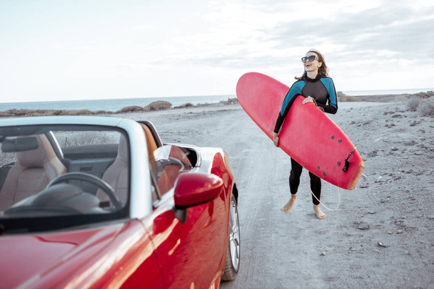 Kobieta z deską surfingową na wybrzeżu - Zdjęcie, obraz