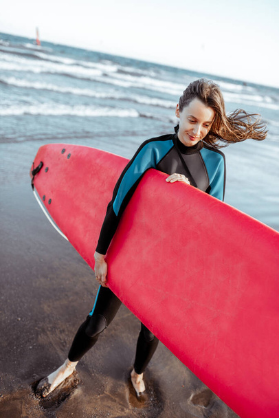 Woman with surfboard on the beach - Foto, afbeelding