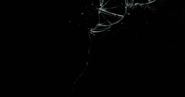 Broken cracks glass fracture effect texture isolated abstract black background. Bullet cracked window with big hole screen mirror weapon shot. - Photo, Image