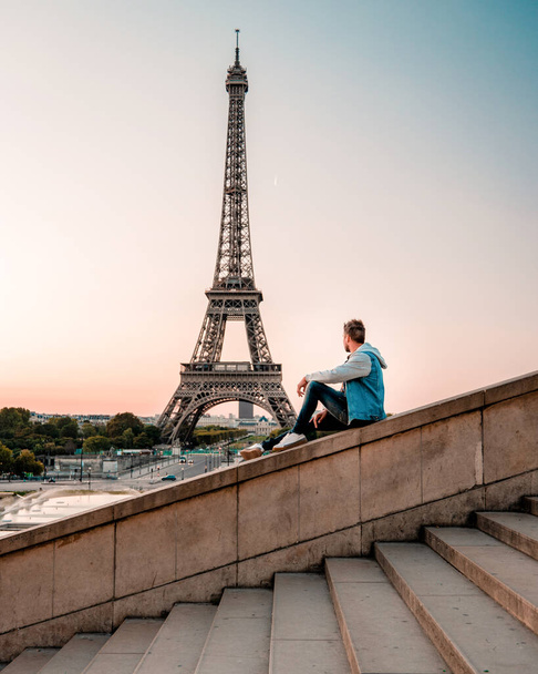 young men watching Eiffel tower in Paris. guy tourist visiting Paris France by eiffel tower - Fotó, kép