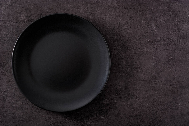 Black plate empty on slate background top view copy space - Fotografie, Obrázek