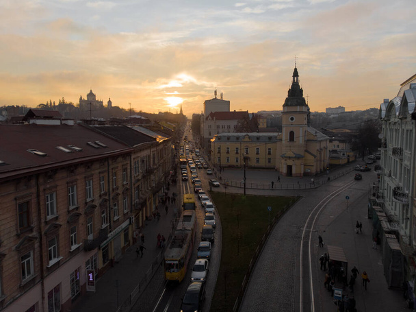 Lviv, Ucrania - 11 de noviembre de 2018: vista aérea del atardecer sobre el antiguo espacio de copia del tráfico de automóviles de la ciudad europea
 - Foto, Imagen