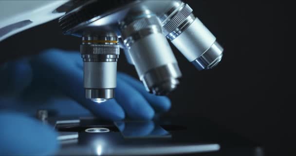 Crop closeup shot of microscope in the laboratory, scientist is conducting study examines - Video, Çekim