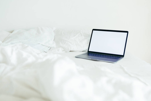 laptop with copy space empty screen at bed with white sheets nobody - Photo, Image