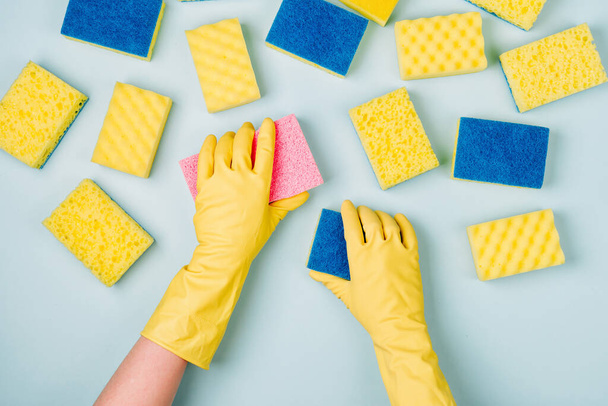 Female hands cleaning with sponge on blue background. Cleaning or housekeeping concept background. Copy space. Flat lay, Top view. - Photo, image