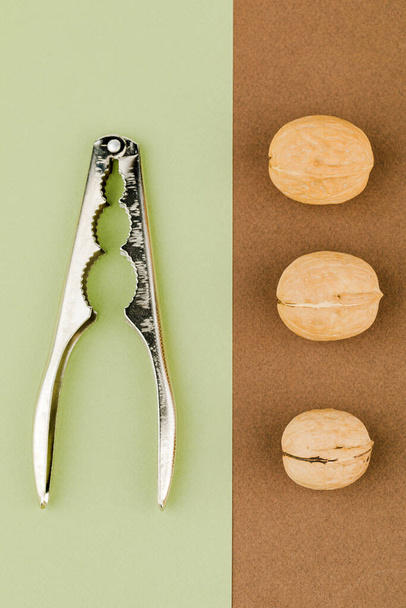 some raw walnuts with nutcracker. - Photo, Image