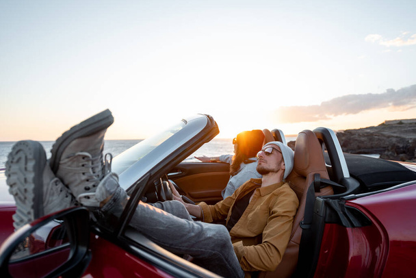 Lovely couple in the cabriolet on a sunset - Photo, Image