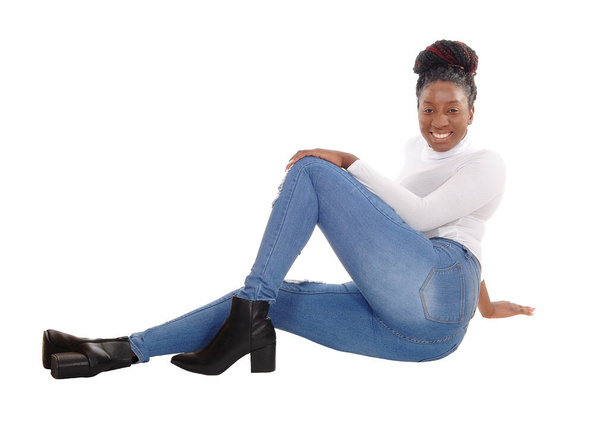 Una hermosa mujer afroamericana alta sentada en jeans y blanco para
 - Foto, Imagen