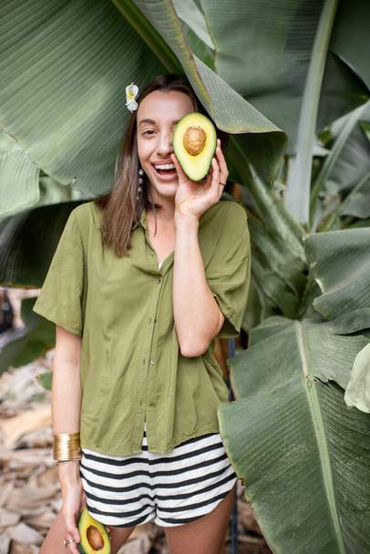 Woman with avocado in banana leaves - Photo, Image