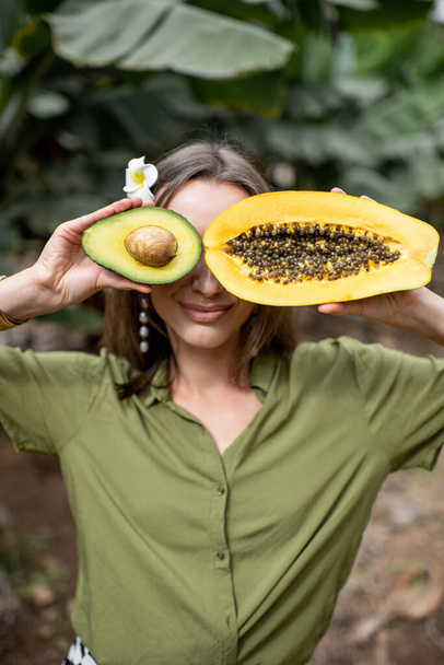 Portrait of a woman with papaya and avocado - Zdjęcie, obraz