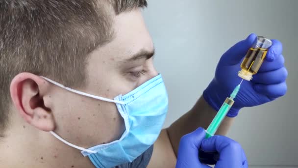 Ο γιατρός κάνει την ένεση μέσα σε μια σύριγγα. Ένας άνδρας γιατρός είναι έτοιμος να χορηγήσει ένα εμβόλιο σε έναν ασθενή. Η έννοια της ανοσοποίησης και του εμβολιασμού του πληθυσμού - Πλάνα, βίντεο