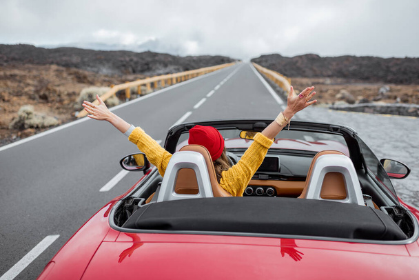 Vrouw reist per cabriolet auto op de vulkanische vallei - Foto, afbeelding