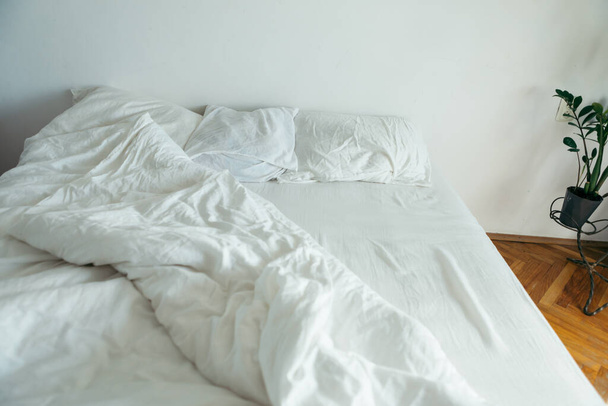 cama con sábanas blancas cerrar brillante luz de la mañana espacio de copia
 - Foto, imagen