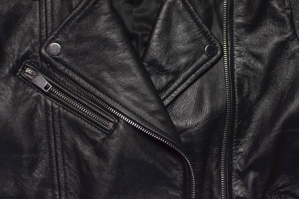Деталі крупним планом Чорна жіноча шкіряна куртка зверху. Модне сучасне модне жіноче вбрання. Вінтажний велосипедний піджак. Чорна натуральна шкіряна текстура
 - Фото, зображення