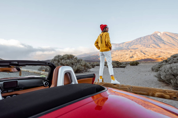 火山の谷を車で旅する女 - 写真・画像