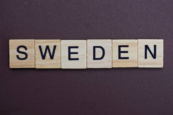  palavra cinza sueco de pequenas letras de madeira em uma mesa marrom
 - Foto, Imagem