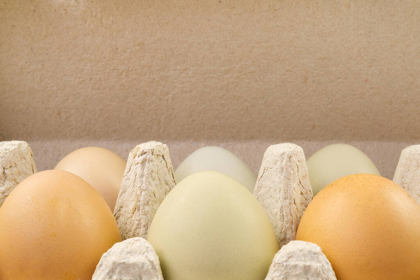 Гусыня и куриные яйца в картонной коробке. Экологические яйца с фермы упакованы в бумажный лоток
 - Фото, изображение