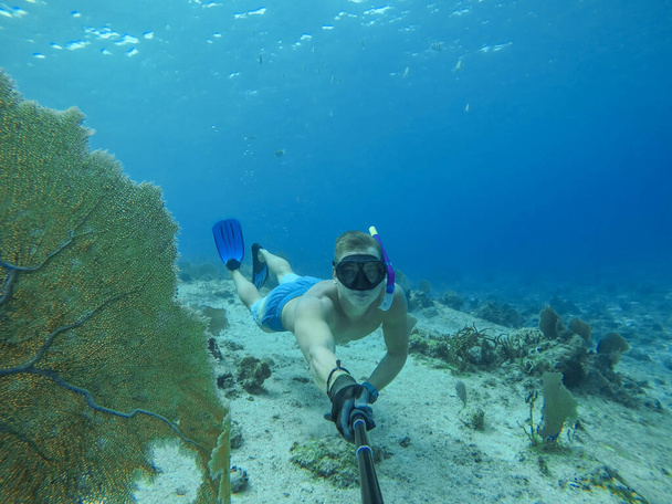 Onderwater groothoek selfie van gespierde zwemmer met een heleboel lamp - Foto, afbeelding