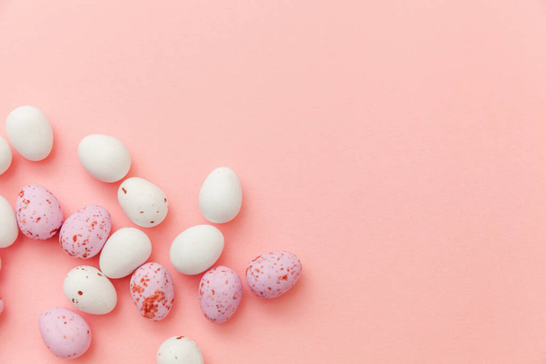 Boldog Húsvéti koncepciót. Készülődés a nyaralásra. Húsvéti csokoládé tojás és zselé édességek elszigetelt trendi pasztell rózsaszín háttér. Egyszerű minimalizmus lapos feküdt felső nézet másolás tér - Fotó, kép