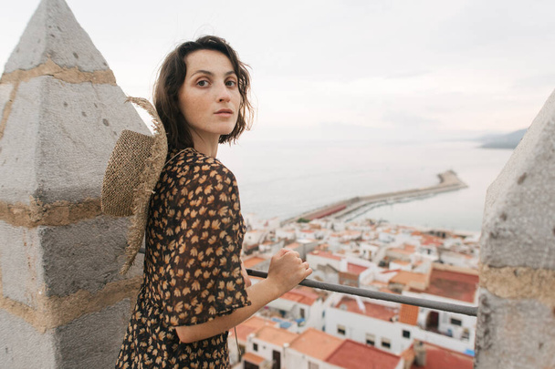young female traveler stands on top of castle, city view, Peniscola Spain - Foto, Imagen