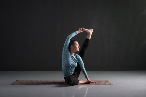 Allenamento di yoga femminile sportivo, seduto in posa Heron, Krounchasana. Aumentare la forza e la flessibilità delle articolazioni e dei muscoli delle gambe. Studio girato
 - Foto, immagini