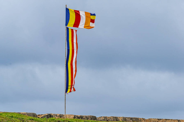 Galle, Sri Lanka - Settembre 2015: Bandiere buddiste battenti un forte vento costiero
 - Foto, immagini